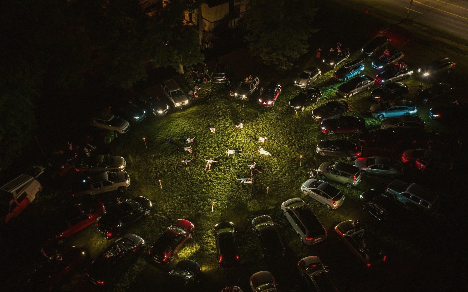 A folding-chair circle in a car park at dusk