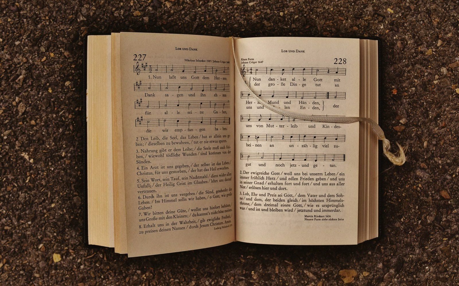 A worn songbook open on a car bonnet